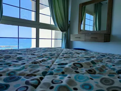 a bedroom with a bed and a large window at جوليانا سما جروب in Hurghada