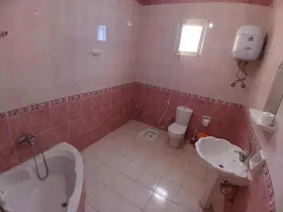 a bathroom with a tub and a toilet and a sink at Sobhy Kana House in Aswan