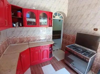 a kitchen with red cabinets and a stove at Sobhy Kana House in Aswan