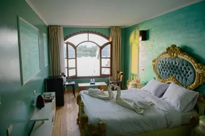 a bedroom with a large bed with a large headboard at Eyaru Palace Nile View in Luxor