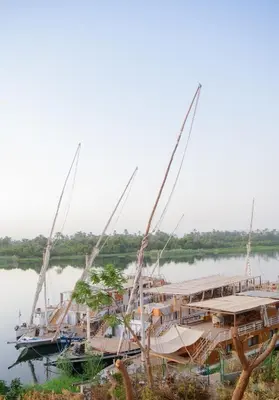 a group of boats are docked on the water at Eyaru Palace Nile View in Luxor