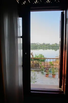 a window with a view of a body of water at Eyaru Palace Nile View in Luxor