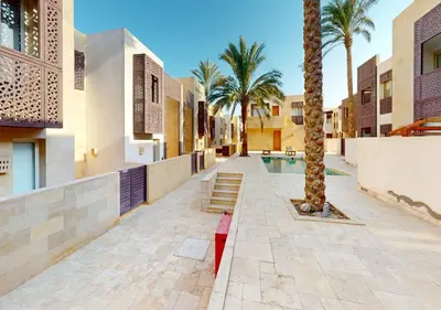 a courtyard with palm trees and a swimming pool at Cozy 2 Bedroom-WS3 at SCARAB Elgouna in Hurghada
