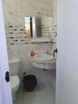 a bathroom with a sink and a toilet and a mirror at Villa Omar El Sharif Studio n1 in Luxor