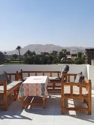 a patio with a table and chairs on a roof at Sekhmet Appartement 3 chambres in Luxor