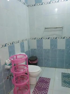 a bathroom with a toilet and pink baskets in it at Sekhmet Appartement 3 chambres in Luxor