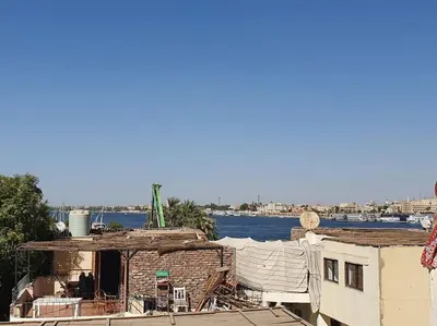 an old brick building next to a body of water at Sekhmet Appartement 3 chambres in Luxor
