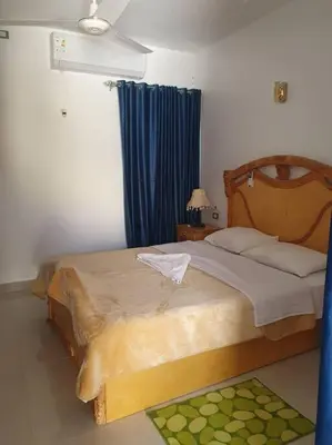 a bedroom with a large bed with a blue curtain at Villa Omar El Sharif Appartement studio n2 in Luxor