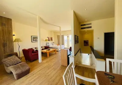 a living room with a red chair and a couch at Warm Studio MB1 at Marina El Gouna in Hurghada