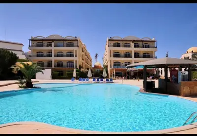 a large swimming pool in front of two buildings at Palm Beach Piazza Beachfront lovely Apartment in Hurghada