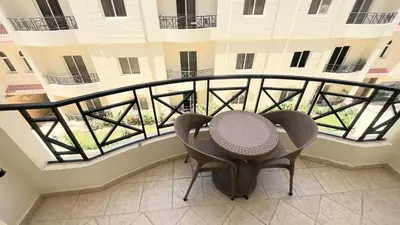two chairs and a table on a balcony of a building at Palm Beach Piazza Beachfront lovely Apartment in Hurghada