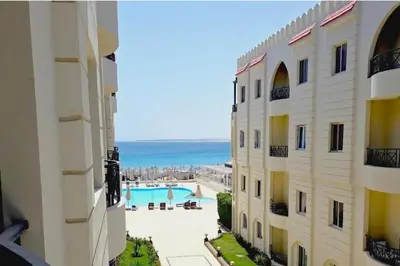 a view from the balcony of a building with a swimming pool at Palm Beach Piazza Beachfront lovely Apartment in Hurghada