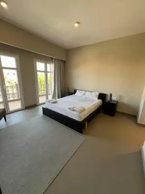 a bedroom with a bed and a large window at Modern Apartment Abutig Marina in Hurghada