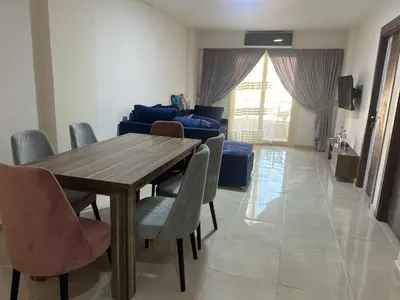 a living room with a wooden table and chairs at Tiba gollden resort in Hurghada