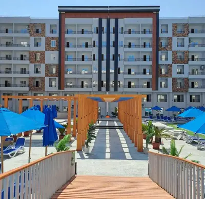 a hotel with blue umbrellas and a building at Tiba gollden resort in Hurghada