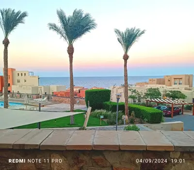 a view of a resort with palm trees and the ocean at one bedroom chalet,with sea view terrace in Hurghada