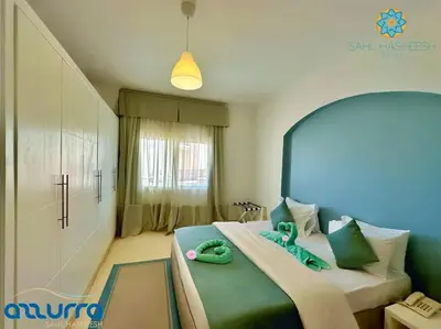 a bedroom with a bed with two green towels on it at one bedroom chalet,with sea view terrace in Hurghada