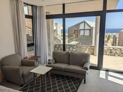 a living room with a couch and a large window at Sea View Studio in Soma Bay With Free Beach & Pool in Hurghada