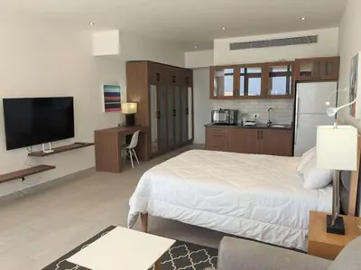 a bedroom with a large white bed and a kitchen at Sea View Studio in Soma Bay With Free Beach & Pool in Hurghada