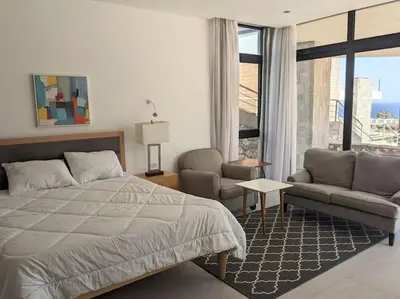 a bedroom with a bed and a couch and a window at Sea View Studio in Soma Bay With Free Beach & Pool in Hurghada