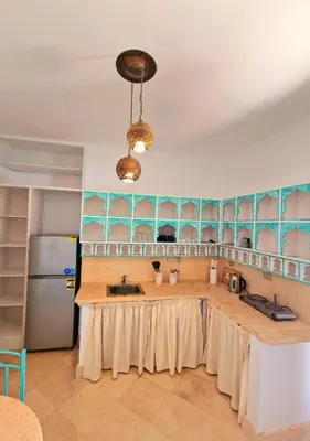 a kitchen with a counter with a sink and a refrigerator at Lovely1 Bedroom Downtown ELGouna F04 in Hurghada