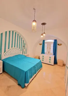 a bedroom with a blue bed and a chair at Lovely1 Bedroom Downtown ELGouna F04 in Hurghada