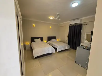 a hotel room with two beds with white sheets at siriuspalaceluxor in Al Karnak