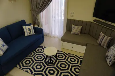 a living room with a blue couch and a table at Casablanca Beach - Panoramic Sea view Apartment in Hurghada