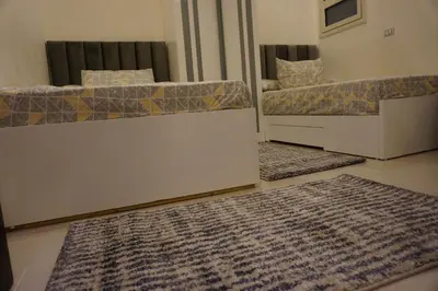 a living room with two beds and a rug at Casablanca Beach - Panoramic Sea view Apartment in Hurghada