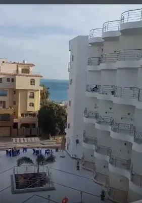 a view of a building with the ocean in the background at Diamond resort compound in Hurghada