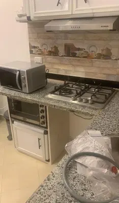 a kitchen with a stove and a microwave on a counter at Diamond resort compound in Hurghada
