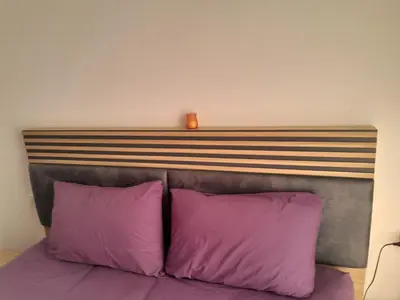 a bed with two purple pillows and a wooden headboard at Cozy Studio in Hurghada bali theme resort in Hurghada