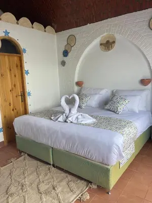 a bedroom with a bed with a swan on it at Dolty Kato Nubian House By Kato Dool in Aswan