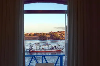 a boat in the water viewed from a window at Dolty Kato Nubian House By Kato Dool in Aswan