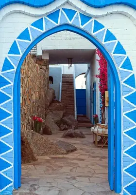 an archway leading into a building with blue doors at Dolty Kato Nubian House By Kato Dool in Aswan