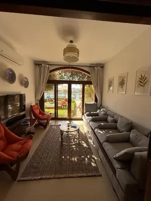 a living room with a couch and a table at 2 Bedroom Ground Floor New Nubia - 2 minutes walk to marina Abu Tig in Hurghada