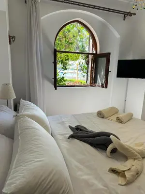 a bedroom with a large white bed with a window at 2 Bedroom Ground Floor New Nubia - 2 minutes walk to marina Abu Tig in Hurghada