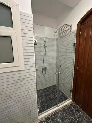 a shower with a glass door in a bathroom at 2 Bedroom Ground Floor New Nubia - 2 minutes walk to marina Abu Tig in Hurghada