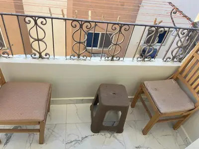 two chairs and a stool sitting on a balcony at Dream apartment1 in Hurghada