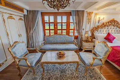 a bedroom with a bed and two chairs and a table at Princess Farida Luxury Dahabiya Nile Cruise, Every Monday from Luxor to Aswan 4 nights and Every Friday from Aswan to Luxor 3 nights in Luxor