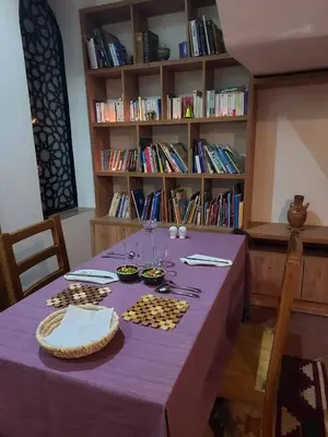 a table with a purple table cloth and a book shelf at Kemet House in Luxor