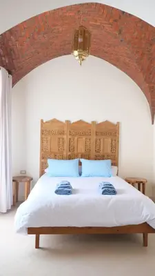 a bedroom with a large bed with a brick wall at Kemet House in Luxor