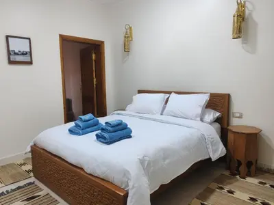 a bed with two blue towels on top of it at Kemet House in Luxor