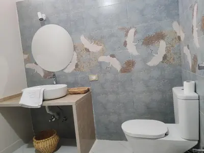 a bathroom with a toilet and a sink and a mirror at Kemet House in Luxor