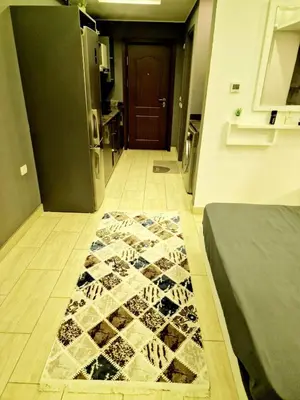a hallway with a rug on the floor in front of a door at Aldau Heights Apartment in Hurghada