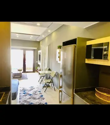 a kitchen with a refrigerator and a dining room at Aldau Heights Apartment in Hurghada