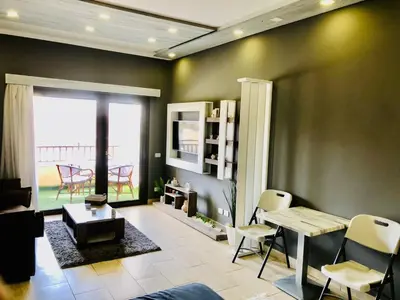 a living room with a table and chairs at Aldau Heights Apartment in Hurghada