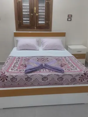 a bedroom with a bed with a bow tie on it at Rawan apartments in Luxor