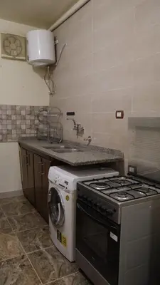 a kitchen with a stove and a washing machine at Rawan apartments in Luxor