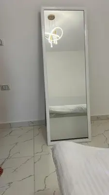 a mirror in a room with a bed and a light at La Prestigia in Hurghada